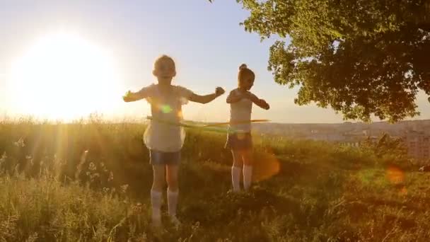 Две девочки играют с хула-хуп — стоковое видео