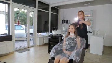 Profesyonel kuaför, saç tokası saç tamir ettiğin için kullanan genç kız için hazırlanıyor stilist