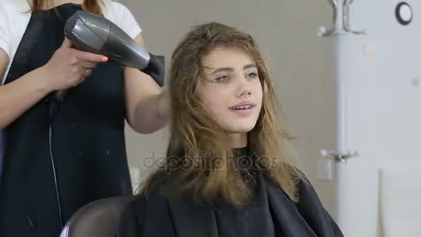 Professioneller Friseur trocknet Haare von süßen Mädchen — Stockvideo