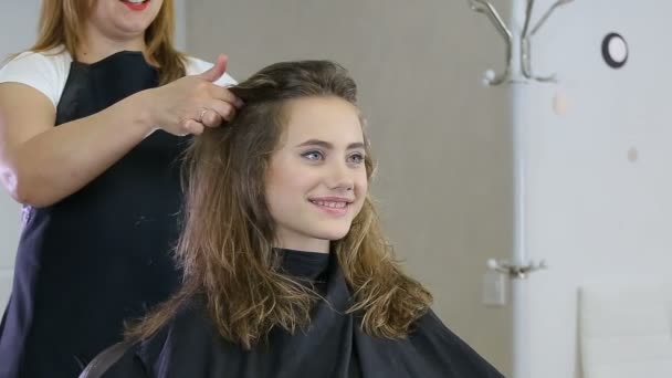 Professioneller Friseur, Stylist, der Frisuren für Teenie-Mädchen vorbereitet, die Frisuren zum Fixieren der Haare verwenden — Stockvideo