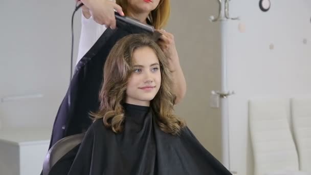 Peluquero profesional estilista acurrucarse adolescente chica cabello — Vídeo de stock