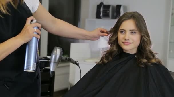 Profesyonel kuaför, saç spreyi için genç kız saç stilist kullanır — Stok video