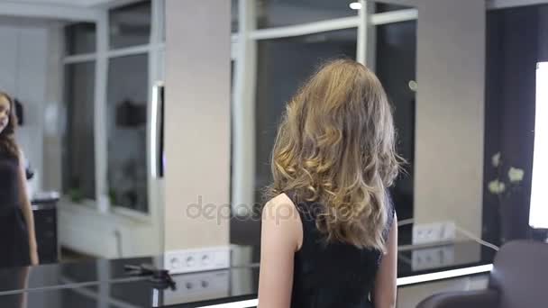 Bonita menina adolescente vira-se e sorri depois de havid hairslyling — Vídeo de Stock