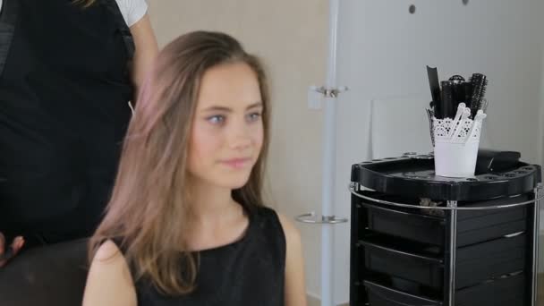 Hairstylist, hairdresser prepares teen girl in white make up room for hairdressing — Stock Video