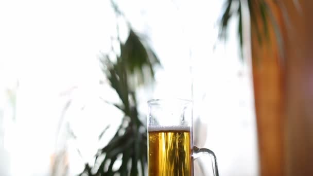 Taza de cerveza medio vacía en la mesa — Vídeos de Stock
