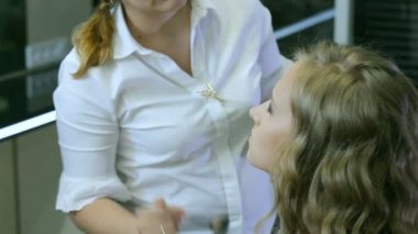 Profesyonel makyaj sanatçısı sarışın modelleri yüz whith cilt fırça temizler.