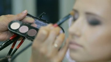 Göz kapağı göz farı yapmak için profesyonel makyaj sanatçısı ton toz sarışın için uygulama modelleri.