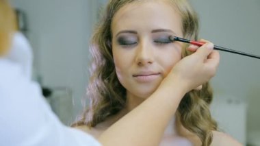 Göz kapağı göz farı yapmak için profesyonel makyaj sanatçısı ton toz sarışın için uygulama modelleri.