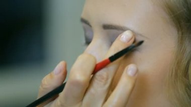 Göz kapağı göz farı yapmak için profesyonel makyaj sanatçısı ton toz sarışın için uygulama modelleri.