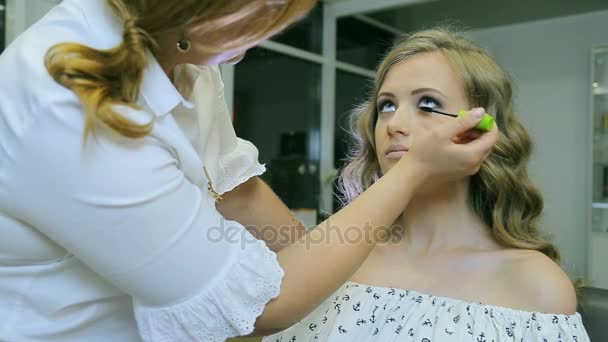 Professionell makeupartist tillämpa mascara till blont modeller ögonfransar. — Stockvideo