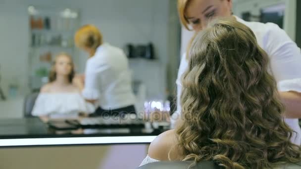 Artista de maquillaje profesional aplicando lápiz de ojos y pincel a modelos rubios párpado para hacer flechas de párpado . — Vídeos de Stock