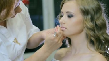 Profesyonel makyöz makyaj genç kadın dudaklar dudak kalemi ile yapar.