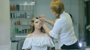 Profesyonel makyaj sanatçısı kadın yüz kozmetik fırça ile temizler