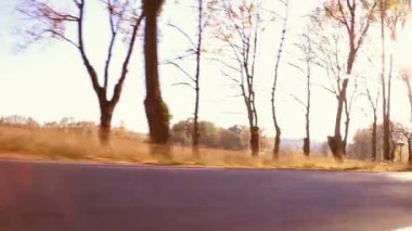 Onun motosiklet sürüş yolda günbatımı sırasında motosikletçi Steadycam atış