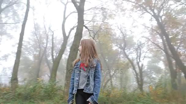 Malá Evropská dívka s dlouhými vlasy, modré sako, černé kalhoty, Kecky a modré oči. Vystrašené malé dítě stojí mlhavé opuštěné lesní. Osamělost. — Stock video