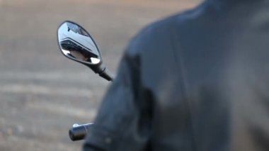 Siyah deri ceket motosiklet oturur bir genç adam beyaz kaskını yolculuk sonbahar gün batımında önce hazırlar