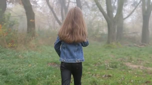 Menina bonita feliz andando pela floresta e falando telefone celular — Vídeo de Stock