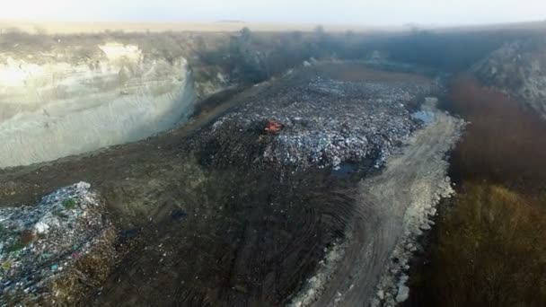 Vzdušný záběr: buldozer pracuje s odpadky v obrovské skládky — Stock video