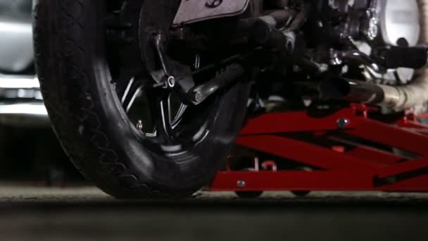 Motorrad wird mit Hebezeug in Werkstatt gehoben. — Stockvideo