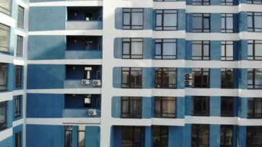 Yeni inşa edilmiş konut evlerinin pencereleriyle birlikte hava görüntüsü ön cephede uçuyor..