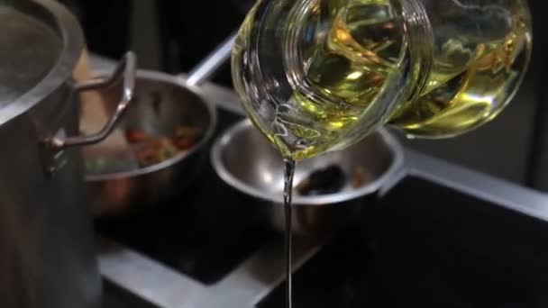 Närbild skott av olja häller i en metallskål. Häll olja från karaffen före matlagning. — Stockvideo