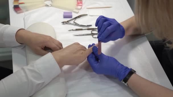 Manicura profesional en guantes puliendo las uñas antes de cubrirlas con barniz . — Vídeo de stock