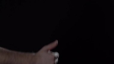 Mans hand shows thumb up and thumb down gestures on black background.