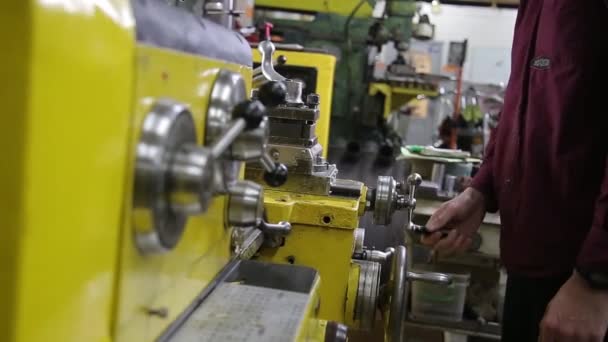 Manos Mans ajustando la máquina de torno durante el afilado de varillas metálicas — Vídeos de Stock