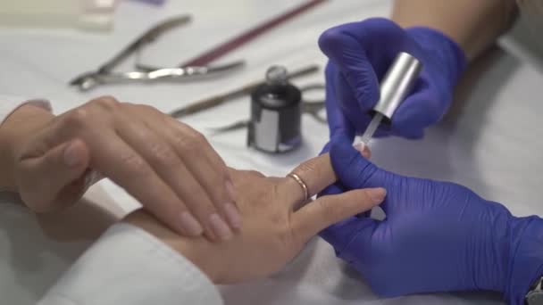 Professionell Manikyrist Handskar Som Täcker Naglarna Med Transparent Lack Närbild — Stockvideo