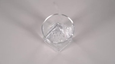 Stüdyo resmi beyaz masada şeffaf camlara dökülüyor. Süper yavaş çekim.