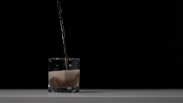 工作室的可乐镜头倒入白色桌子上的透明玻璃杯中 黑色背景 漂亮的棕色泡沫 超级慢动作 — 图库视频影像