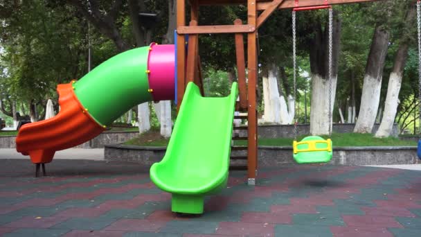 Bonito bebê menina montando em um slide infantil — Vídeo de Stock