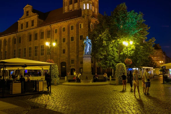2016年9月 不明身份的人走过 Nicolaus 哥白尼在托伦老城中心的雕像 — 图库照片