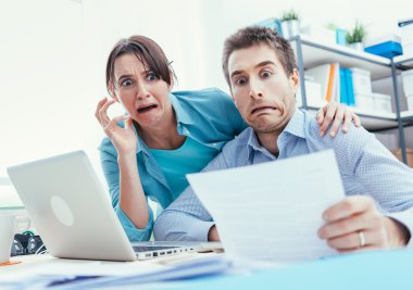 Stressed young couple checking bills