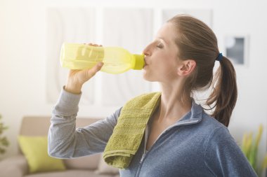 Sporty woman drinking water clipart