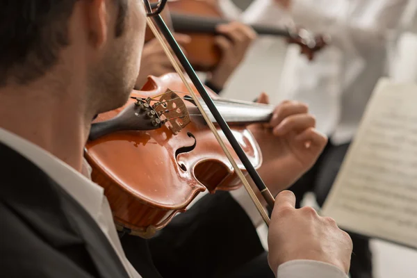 Violinist performing on stage with orchestra — Stock Photo, Image