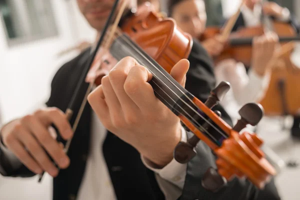 Violinist performing on stage with orchestra — Stock Photo, Image