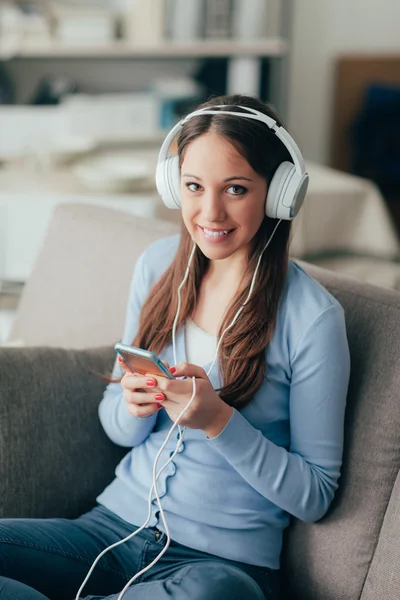 Leende kvinna lyssnar musik — Stockfoto