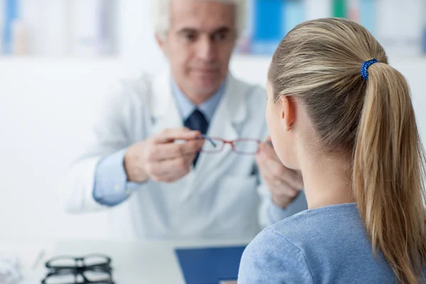 Οπτικός δίνοντας γυαλιά για τον ασθενή — Φωτογραφία Αρχείου