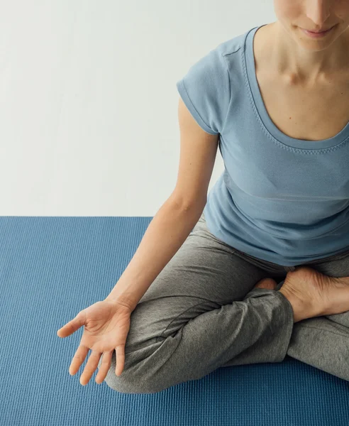 Kvinna som utövar yoga hemma — Stockfoto