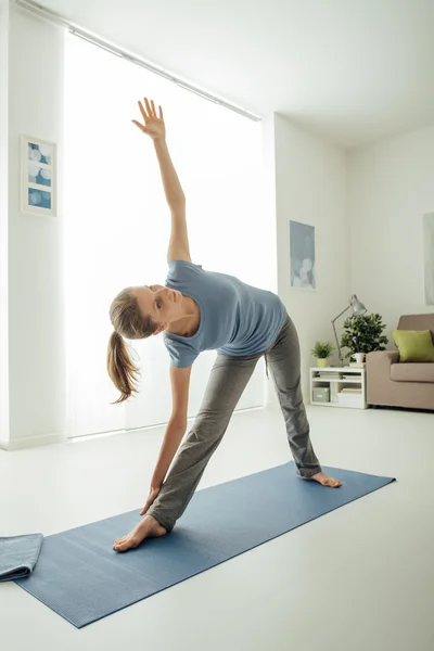Девушка практикует йогу дома — стоковое фото