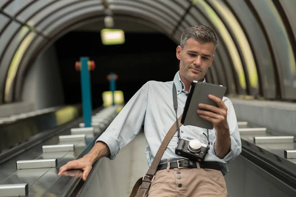 Muž s tabletem na eskalátoru — Stock fotografie