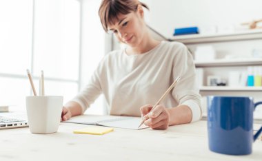 Genç kadın bir defter üzerinde çizim