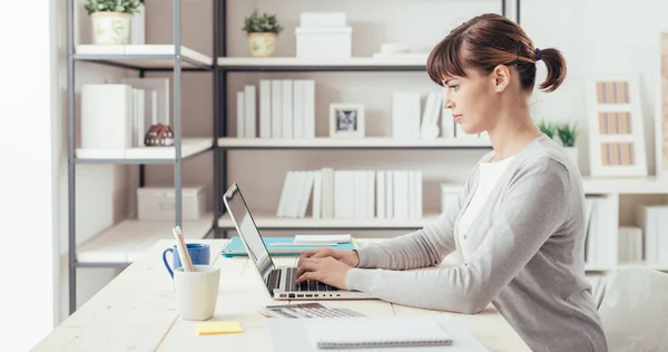 Junge Büroangestellte arbeitet am Schreibtisch — Stockfoto