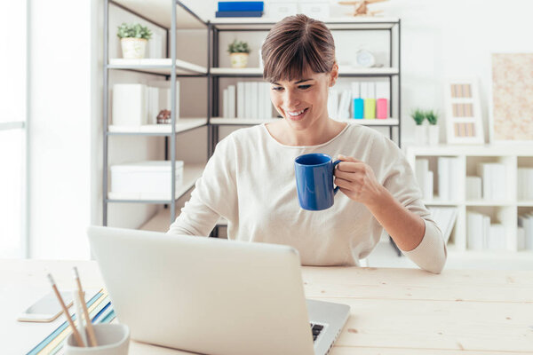 У женщины перерыв на кофе и общение в сети
