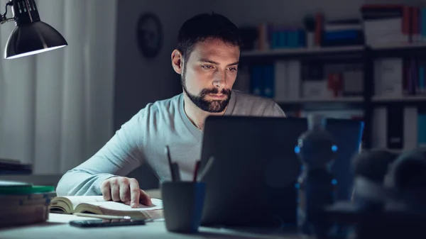 Jovem sentado na mesa e estudando — Fotografia de Stock