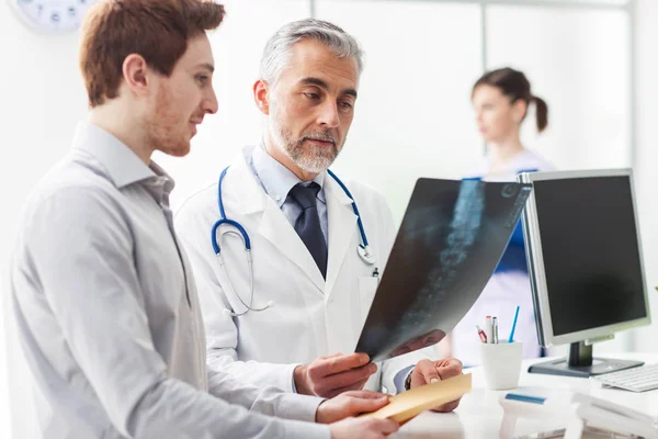 Médico que examina a radiografia de um paciente — Fotografia de Stock