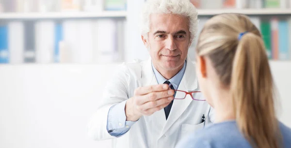 Optiker ger glasögon till patienten — Stockfoto