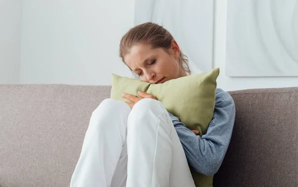 Mujer triste abrazando una almohada —  Fotos de Stock