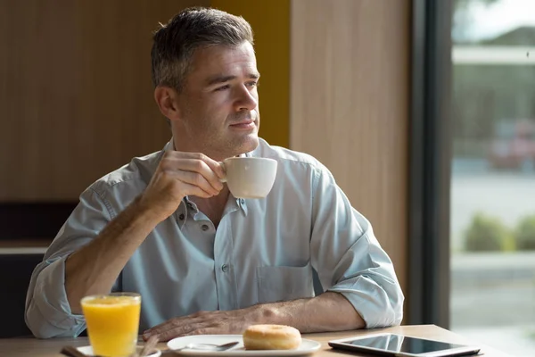 Businessman at the bar having a cup of coffee — Stock Photo, Image